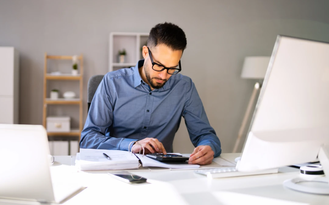 A business owner in Upper Falls, MD looking stressed while trying to fix messy financial records on a computer.